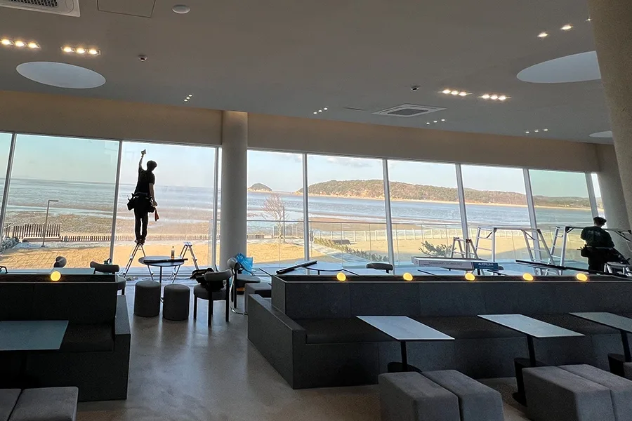 고소 사다리 위에서 통유리 상단까지 단열필름을 밀착 시공하는 기사