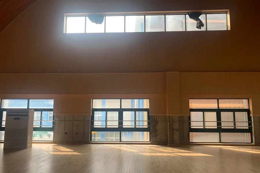 천장 가까이 위치한 고측창에 시공을 마친 모습, 창밖으로 인근 건물이 비치는 실내 전경